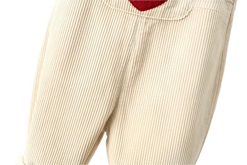 Close up of the crotch of the cream baby corderoy overall pants.