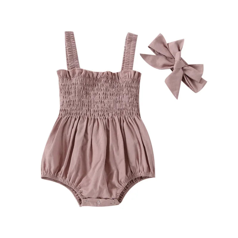 Pink infant romper with elastic straps at the shoulder a snap bottom and an elastic top with a bow.