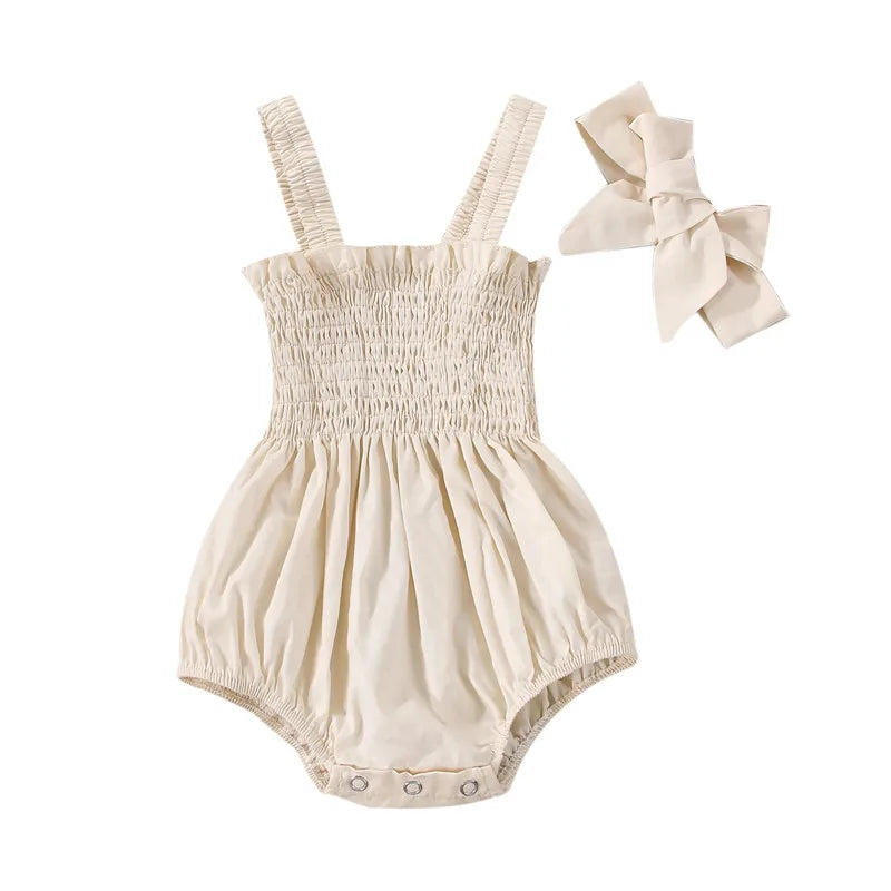 Ivory infant romper with elastic straps at the shoulder a snap bottom and an elastic top with a bow.