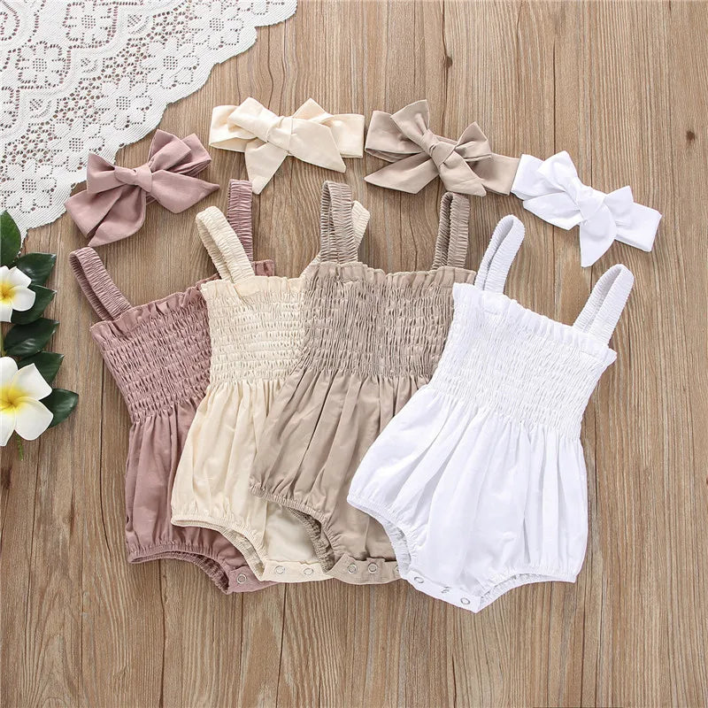 4 colorts of infant romper with elastic straps at the shoulder a snap bottom and an elastic top with a bow.