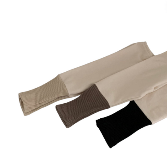 Baby leggings in beige with darker cuffs that are very long.