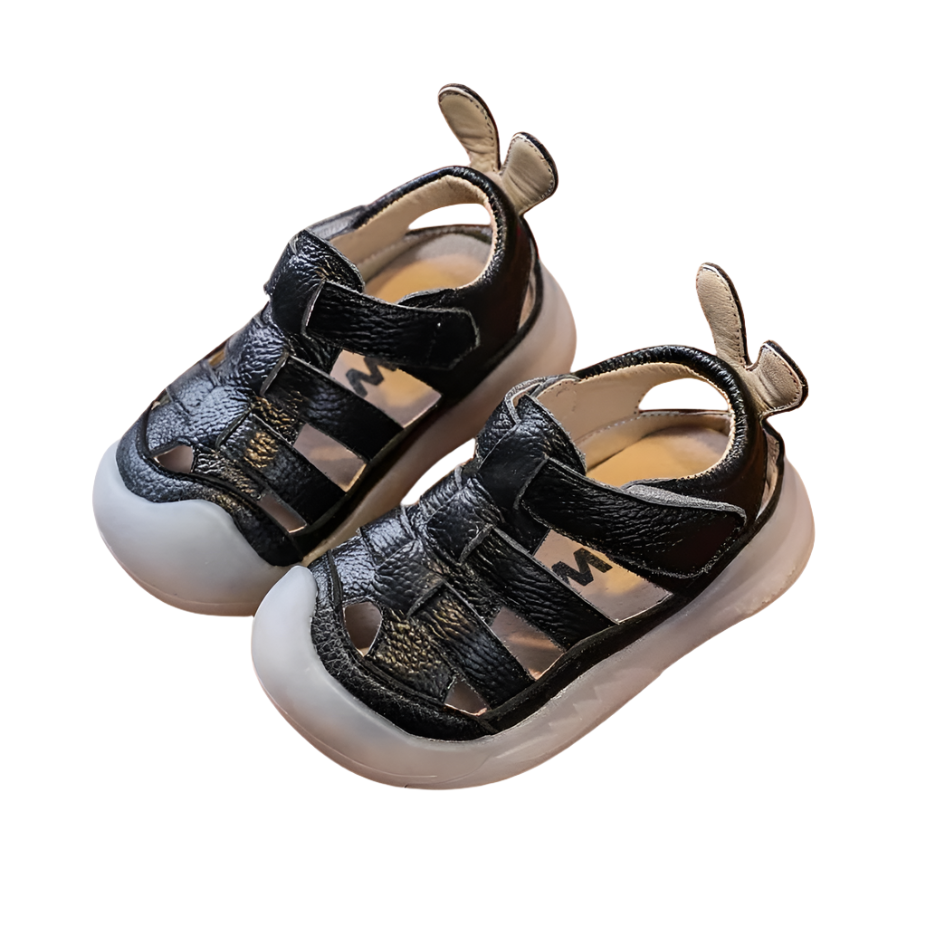 Black leather strap sandals with a velcro closure bor babies and toddlers.