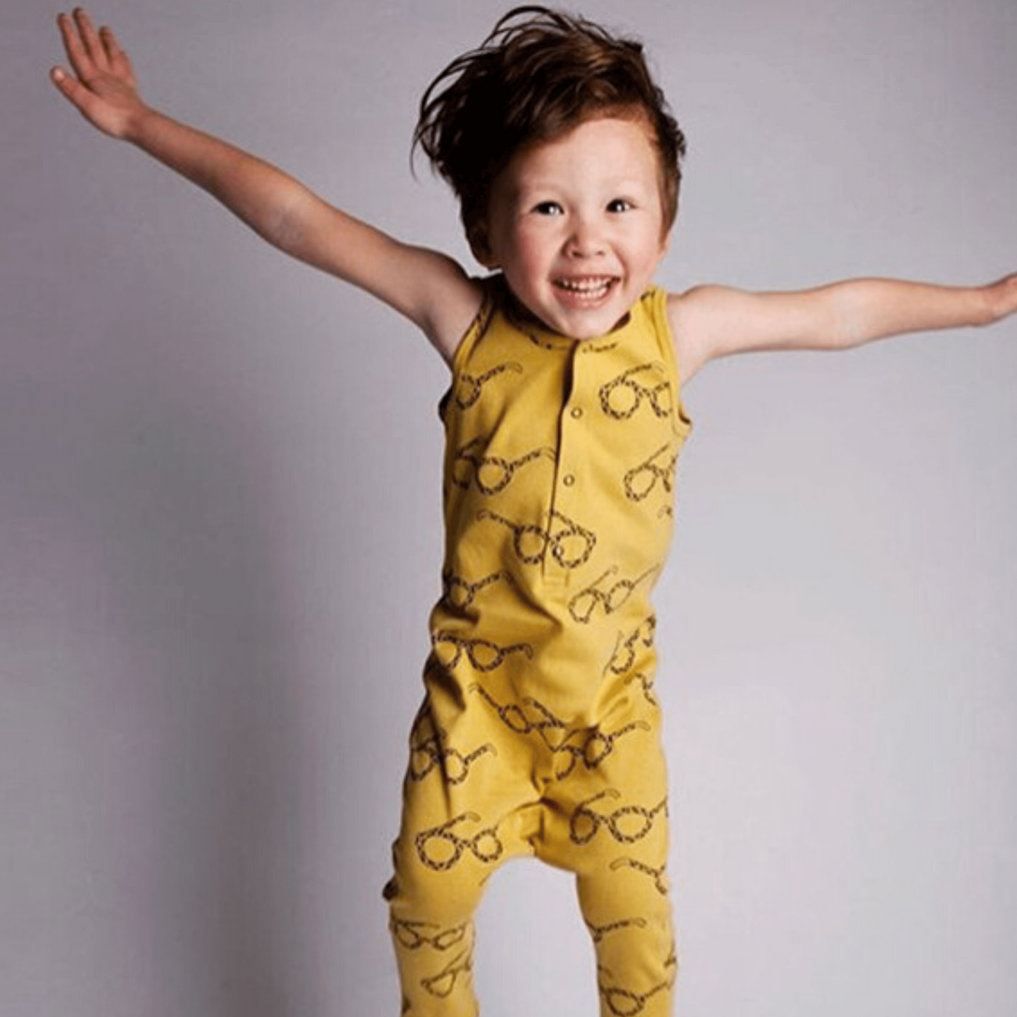 Boy wearing a unisex baby and toddler Rompers snap bottom tank with long pants and snap half front in yellow with glasses graphics
