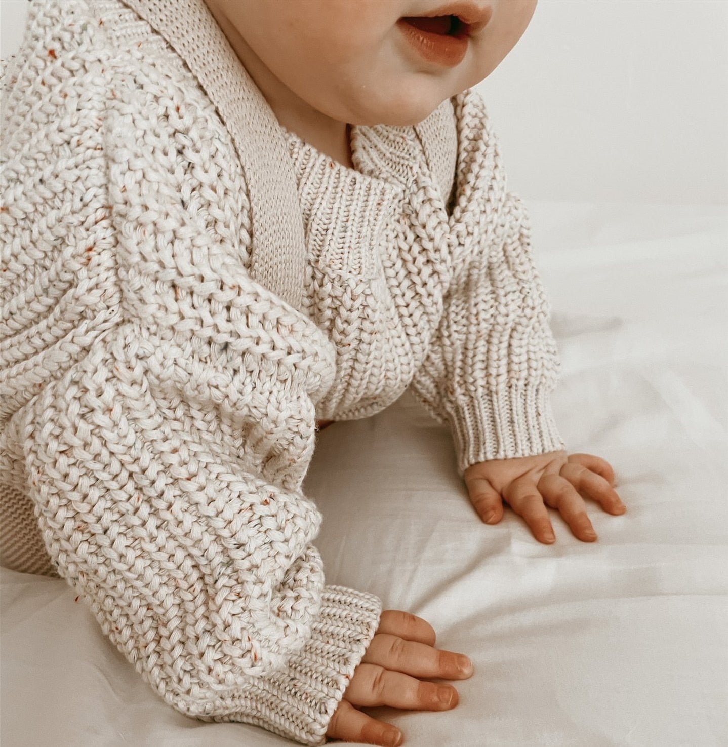 A baby wearing. chunky knit baby sweater in Ivory