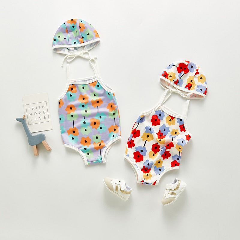 Infant bathing suit with floer graphics and a hat.