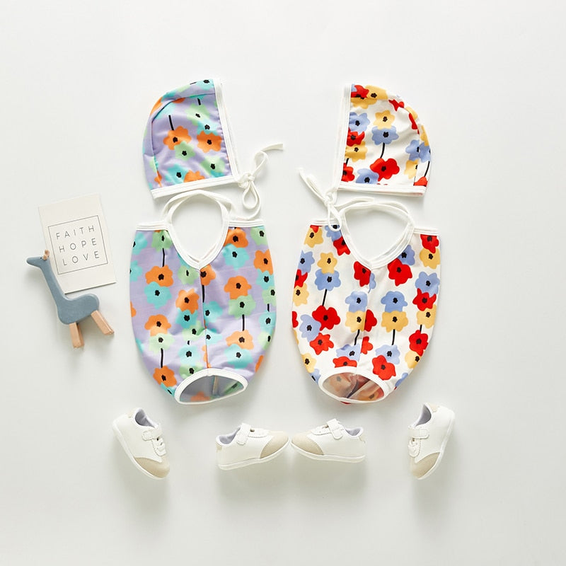 Infant bathing suit with floer graphics and a hat.