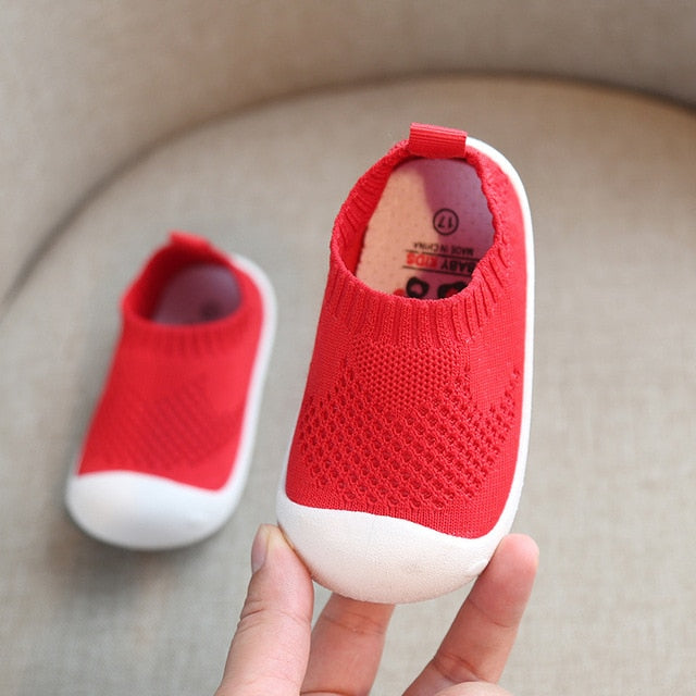 White rubber bottom kids shoes with bright red uppers that are like ankle socks.