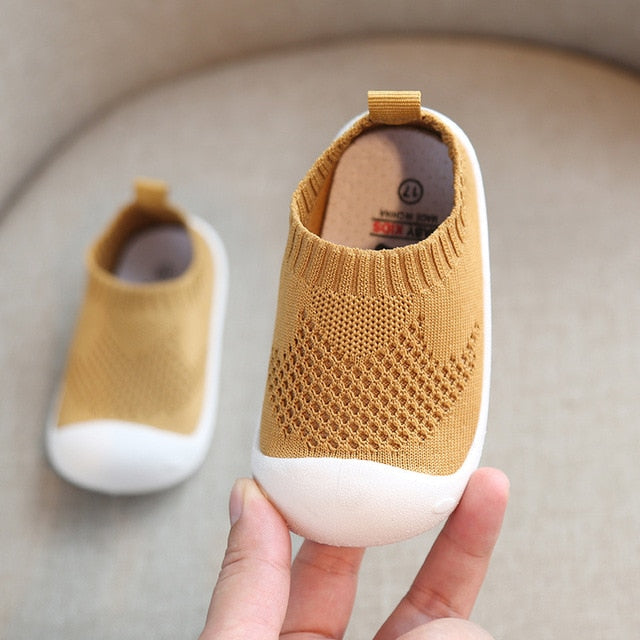 White rubber bottom kids shoes with mustard yellow uppers that are like ankle socks.