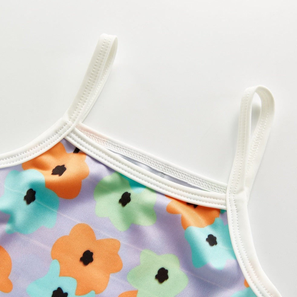 strappes for Infant bathing suit with floer graphics and a hat.