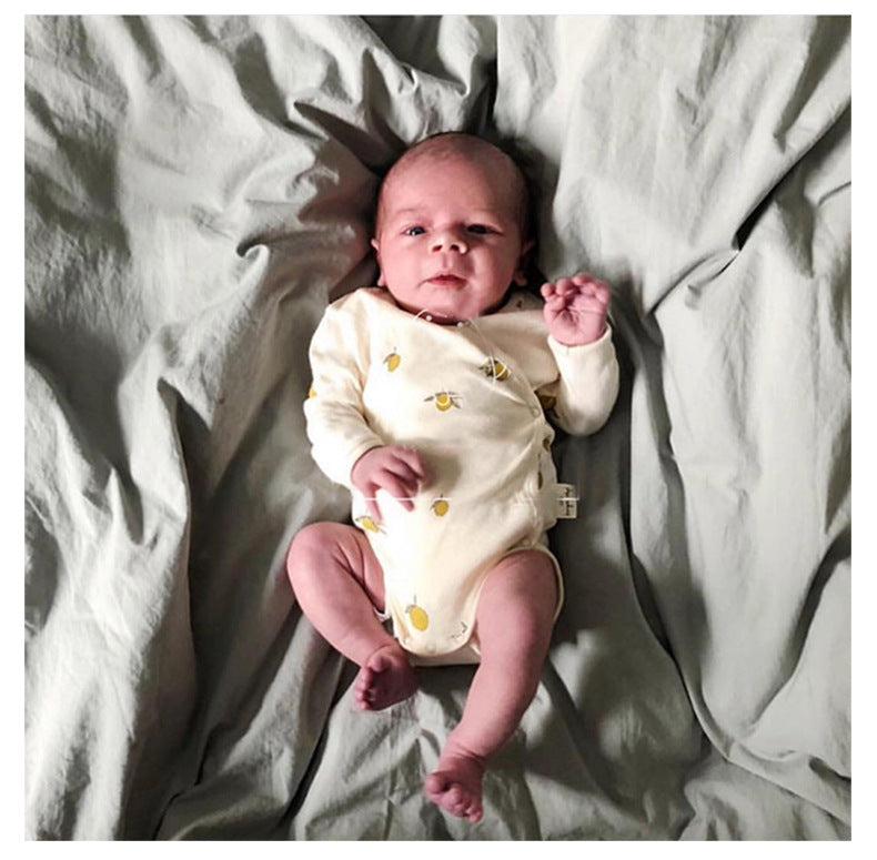 newborn wearing a long sleeved onesie with side and bottom snaps with lemon pattern