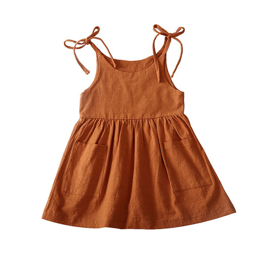 summer toddler dress with ties at the shoulder, ruffled skirt, and front pockets in rust.