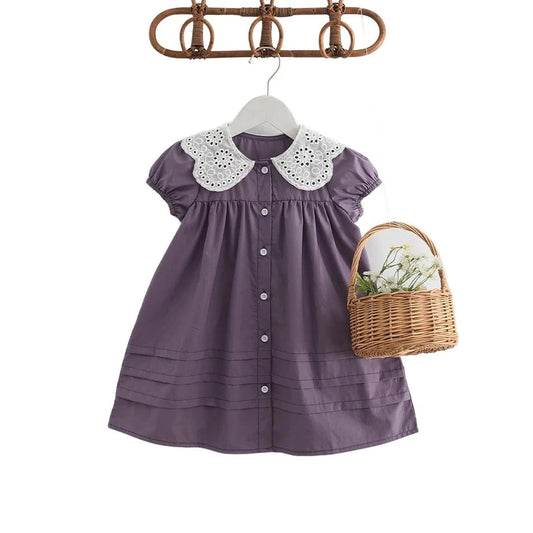 Old fashioned girls dress in purple with a lace collar. 