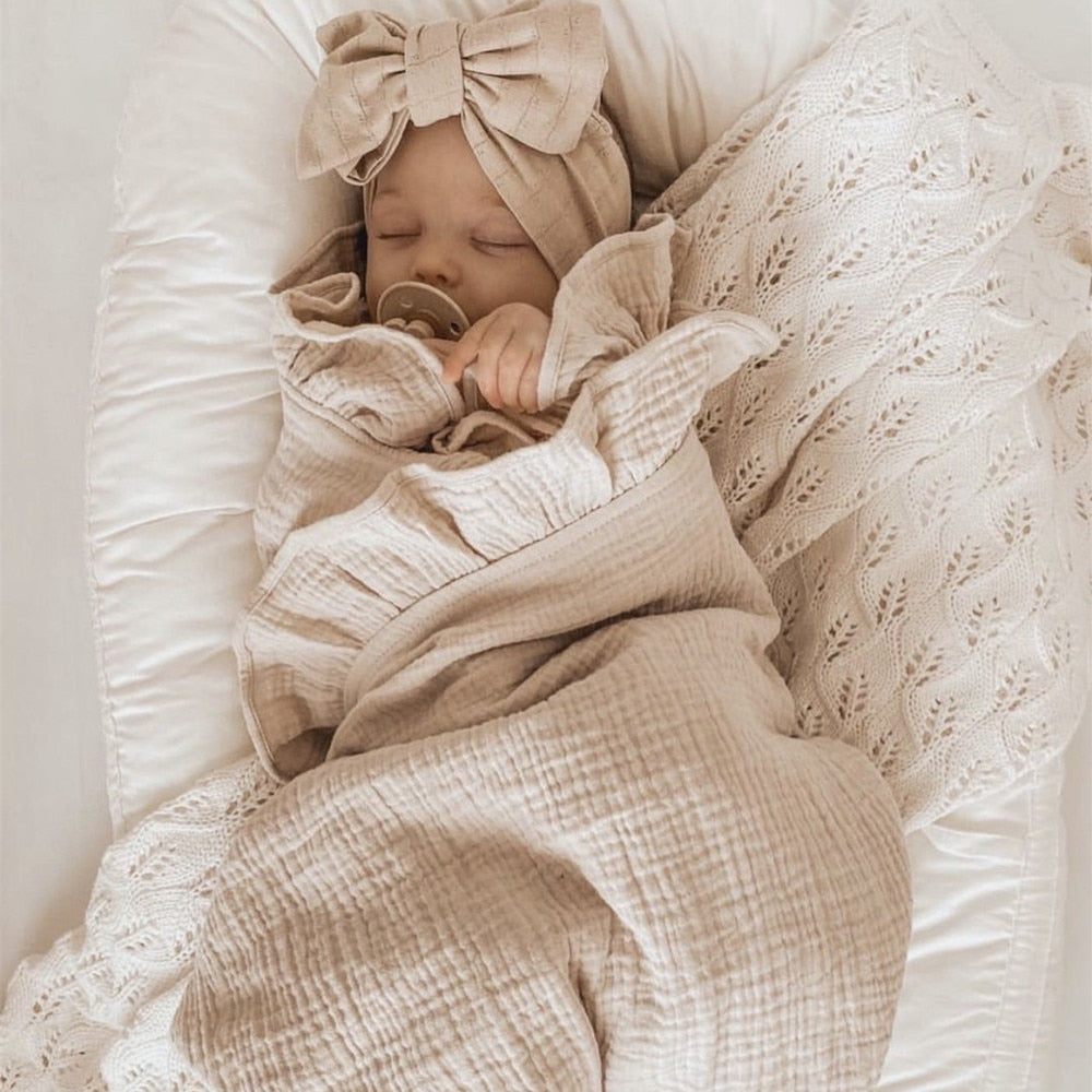 infant swaddled in a Ruffled Muslin Baby Swaddle Blankets 