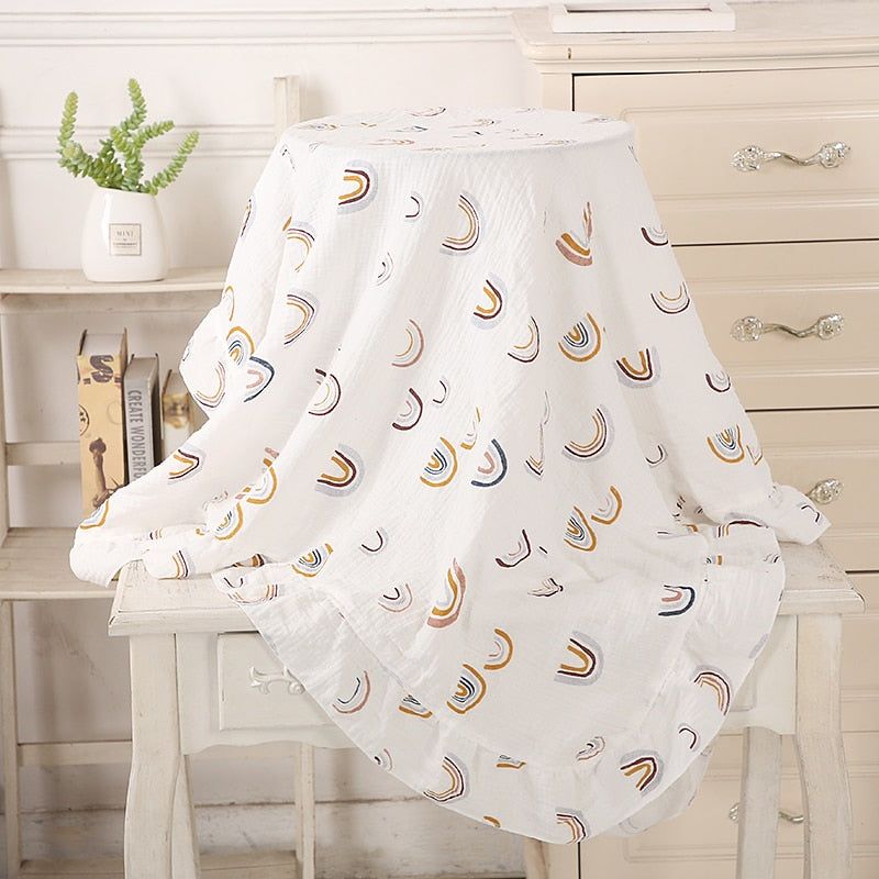 white with rainbows organic cotton recieving blanket with ruffles in the edge. 
