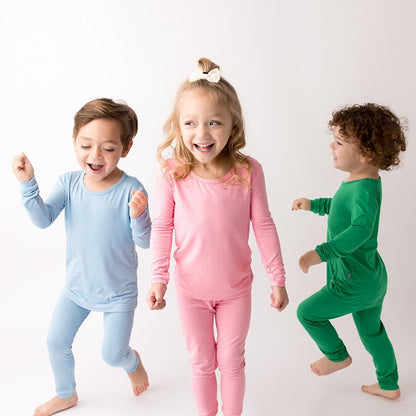 3 kids dancing wearing bamboo pajamas in green, blue and pink