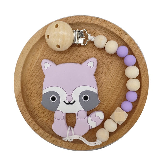 Purple  Raccoon Silicone and Wood Pacifier Clip and teether set in wooden circular tray