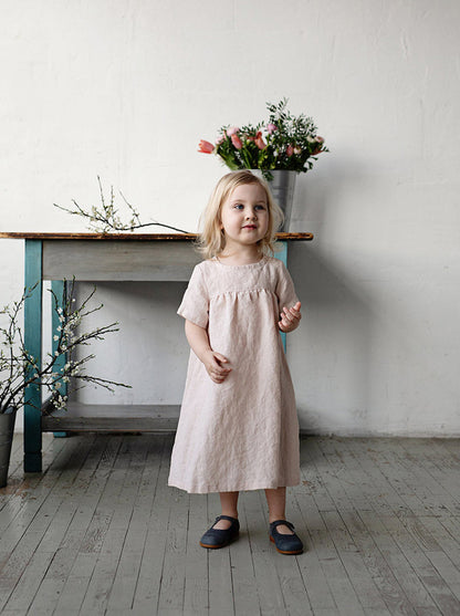 super cute little girl wearing linen summer dress.