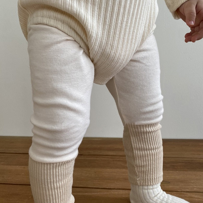 Achild wearing beige tights with double ribbing at the bottom. 