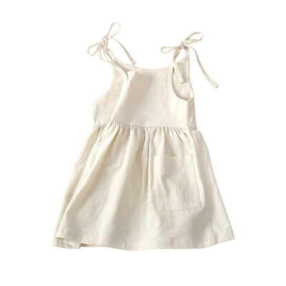 summer toddler dress with ties at the shoulder, ruffled skirt, and front pockets in ivory